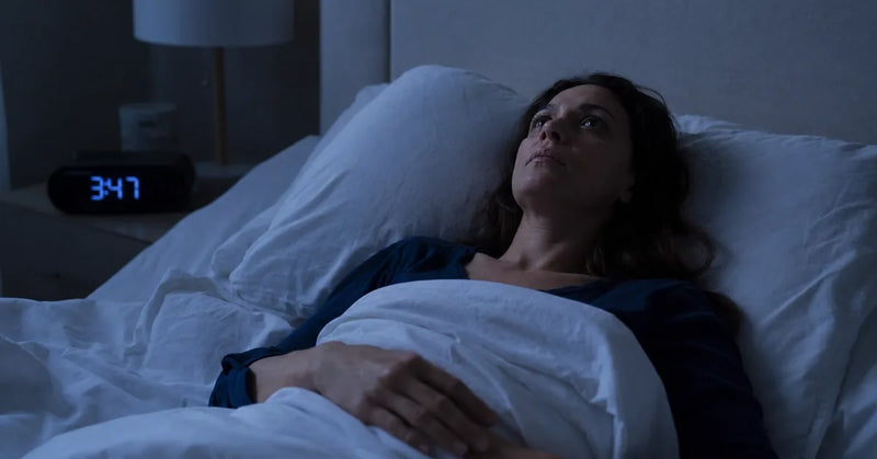 Woman lying awake in bed at night with perimenopause insomnia, magnesium glycinate for sleep